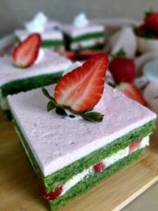 Sliced Strawberry Spinach Cake in a wooden board 