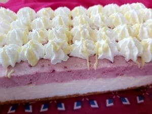 Close-up of a no-bake raspberry cake topped with whipped cream. 