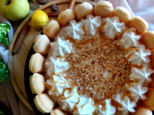 Golden Caramel Apple Charlotte topped with caramel sauce and chopped hazelnuts.