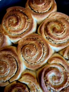 Close-up of golden baked walnut, orange & mahleb rolls.