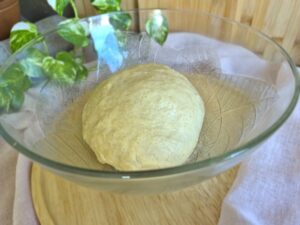 Kneaded yeast dough in a mixing bowl ready for first rise.