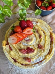 Strawberry Rolled Layer Cake on a platter garnished with fresh strawberries.
