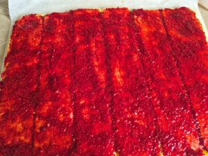 Raspberry filling spread over sliced sponge base.