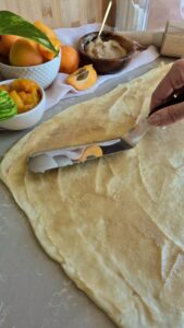 Close-up of spreading the filling for Apricot Honey Rolls 