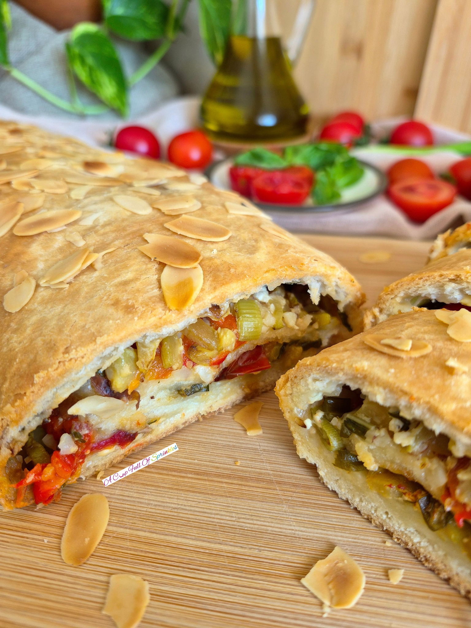 Golden baked and sliced Summer Veggie Roll with roasted vegetables in the background.