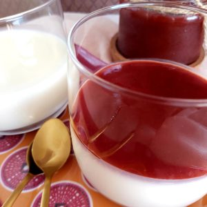 Panna Cotta in a glass on a decorative plate.