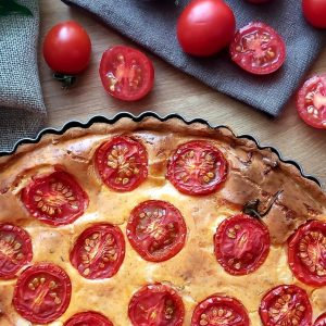 Close up of baked tomato Zucchini Quiche in a baking dish.